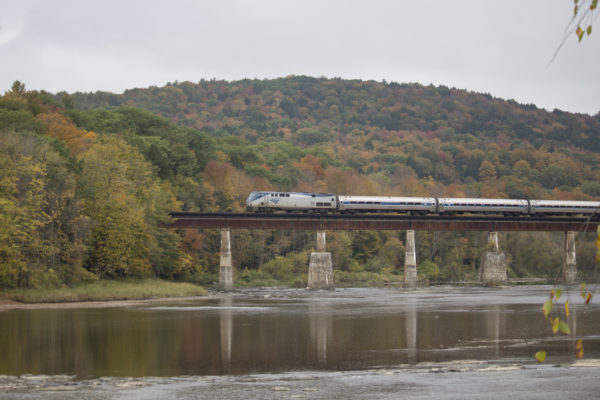Against the beautiful fall foliage for which New England is famous, the southbound Vermonter crosses the White River at West Hartford, Vermont.