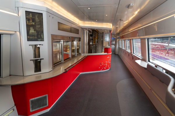 The café car will offer more convenient food service, including a self-select and check-out option, a standing room area with hip rests, electrical outlets for charging, digital screens sharing useful information, and one-half of the trash receptacles will be for recycling.