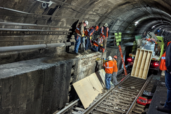 Amtrak engineering forces use jackhammers, crowbars and other tools to remove loose and unstable concrete from the North River Tunnel benchwall in preparation for new concrete to be poured as part of ongoing interim reliability improvements.