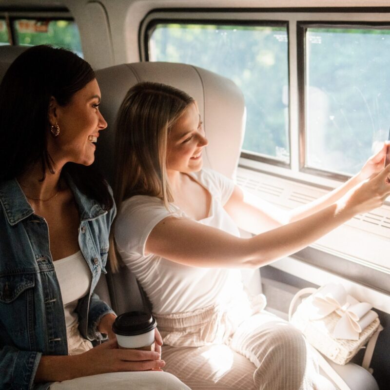 Two female Amtrak customers taking a selfie while sitting in their seats on the train