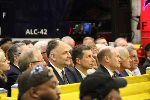 Amtrak CEO Stephen Gardner sits next to Secretary Buttigieg during the event.