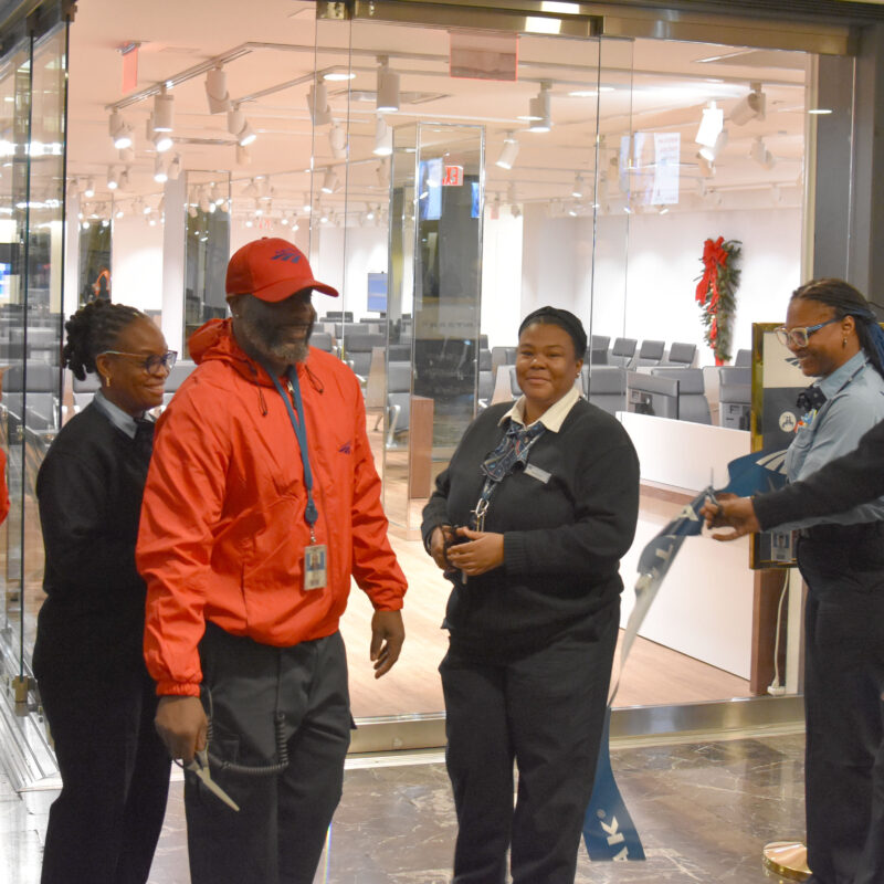 Amtrak employees cutting a ribbon.