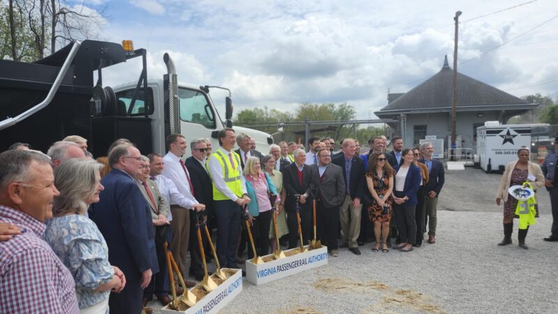 A group of people standing outside and holding shovels.