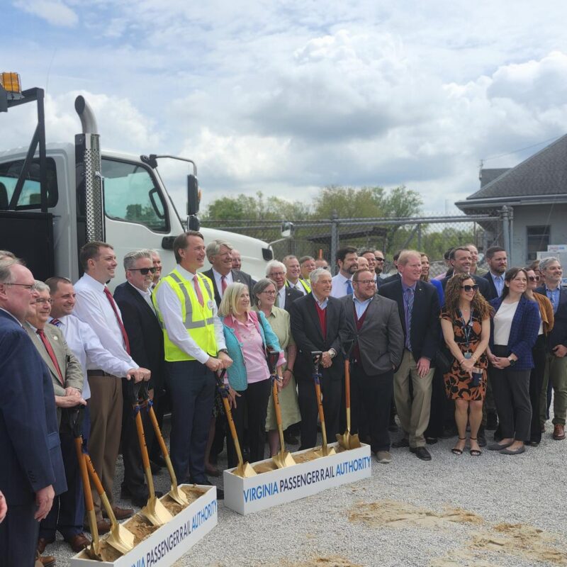A group of people standing outside and holding shovels.