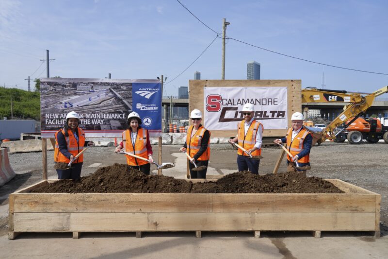 Amtrak and partners post for a groundbreaking photo with dirt on shovels at Sunnyside Rail Yard