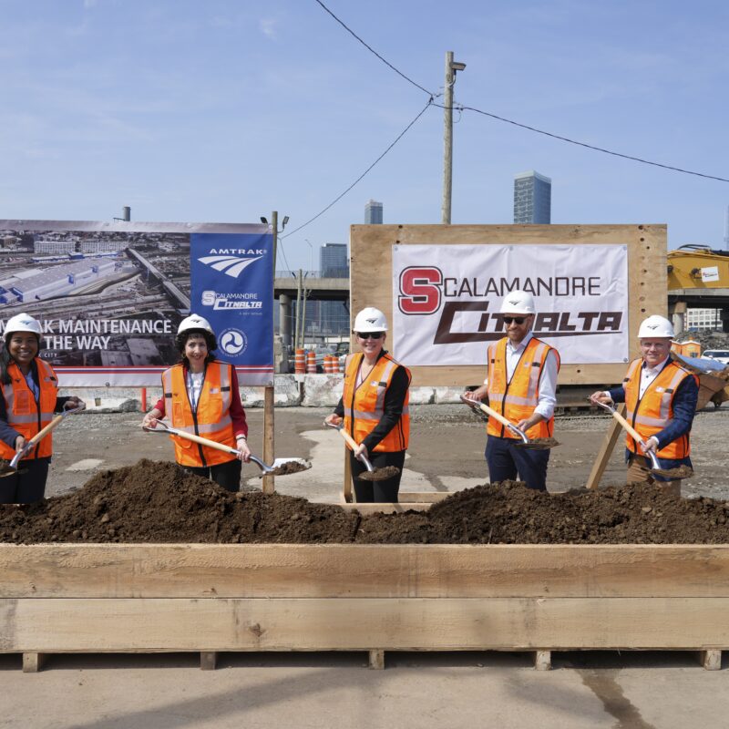 Amtrak and partners post for a groundbreaking photo with dirt on shovels at Sunnyside Rail Yard