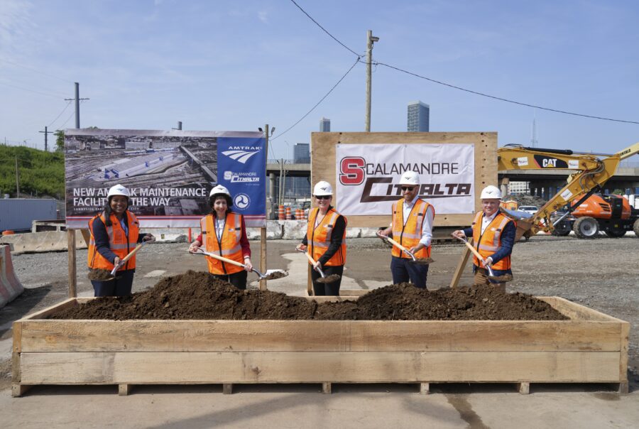 Amtrak and partners post for a groundbreaking photo with dirt on shovels at Sunnyside Rail Yard