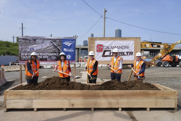 Amtrak and partners post for a groundbreaking photo with dirt on shovels at Sunnyside Rail Yard